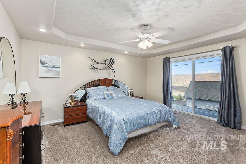 2924 27th Street Clarkston, WA 99403 - Photo 21 of 36 Bedroom featuring a raised ceiling, light carpet, access to exterior, recessed lighting, and a textured ceiling