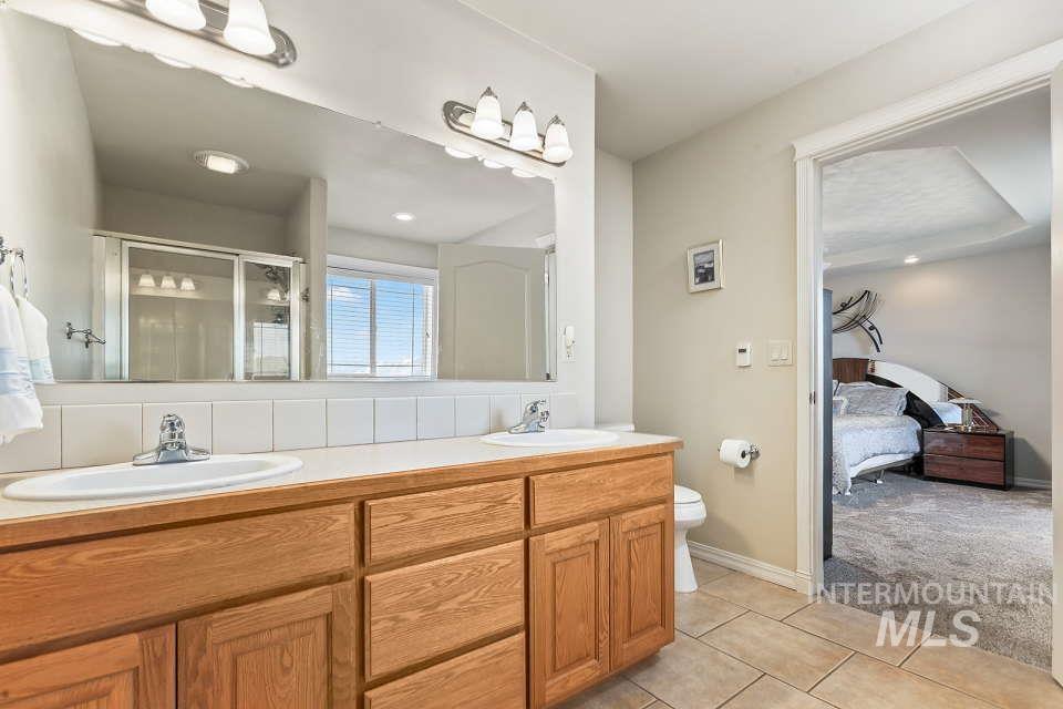 2924 27th Street Clarkston, WA 99403 - Photo 26 of 36 Ensuite bathroom with tile patterned flooring, a shower stall, and double vanity