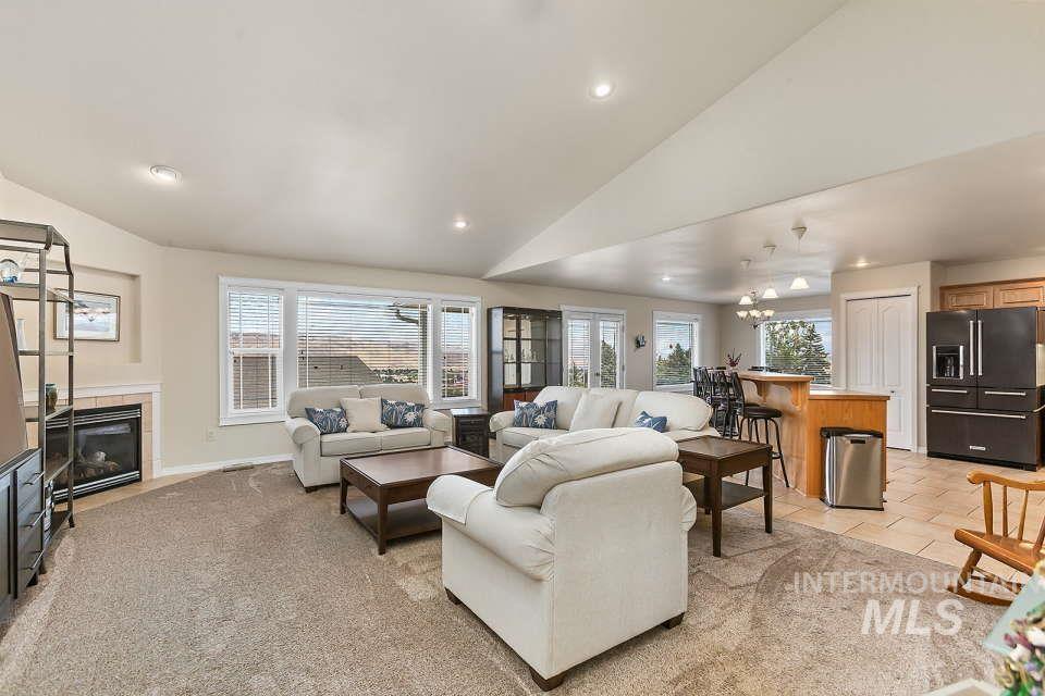 2924 27th Street Clarkston, WA 99403 - Photo 7 of 36 Living room with recessed lighting, a tiled fireplace, light tile patterned floors, high vaulted ceiling, and light colored carpet