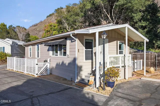 a view of a house with a yard and wooden fence