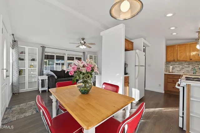 a dining room with furniture potted plants and wooden floor