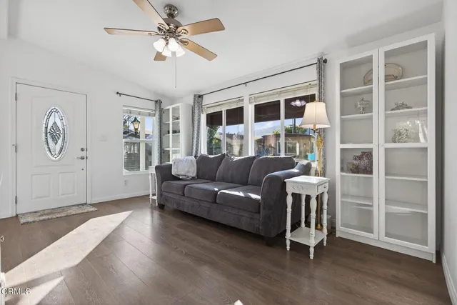 a living room with furniture a large window and a ceiling fan
