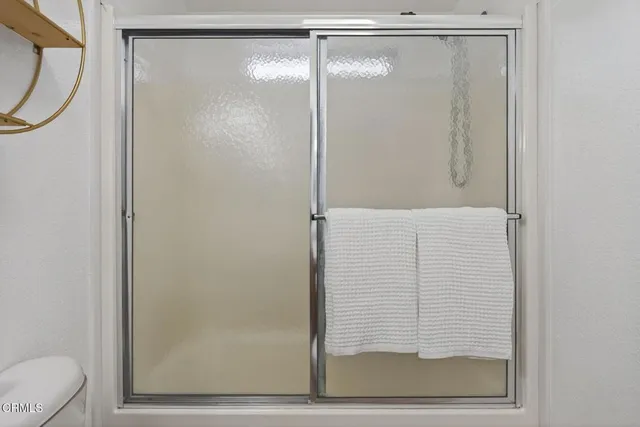 a bathroom with a granite countertop sink a toilet and a mirror