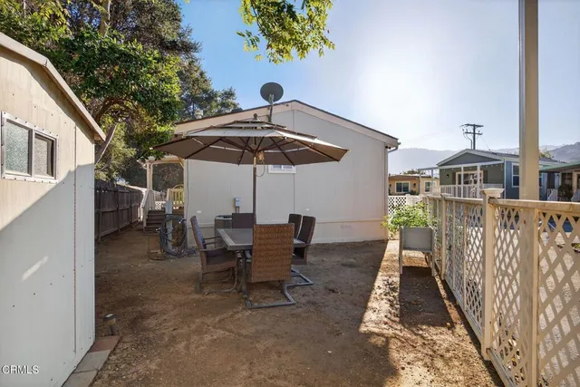 a view of a chairs and table under an umbrella in the patio