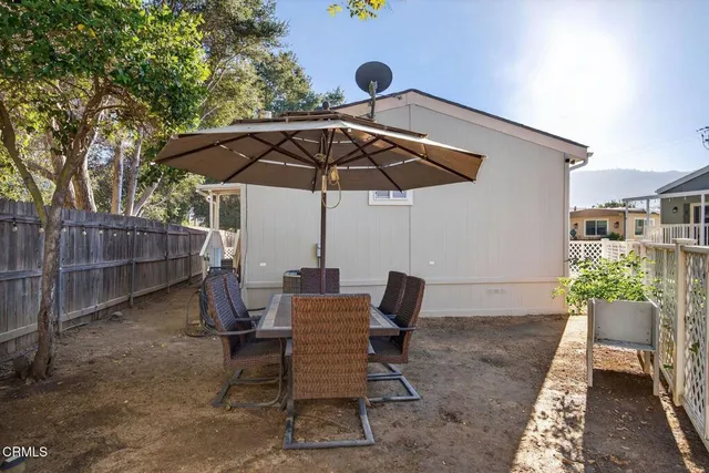 a view of wooden table and chairs under an umbrella