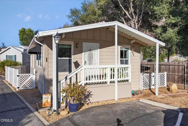 a view of a house with a yard and wooden fence