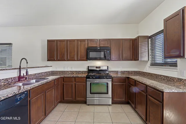 a kitchen with stainless steel appliances granite countertop a stove sink and cabinets