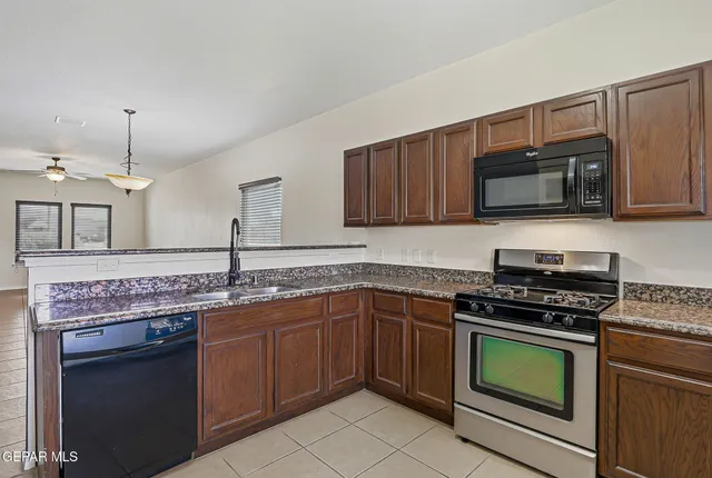 a kitchen with granite countertop a stove and a microwave