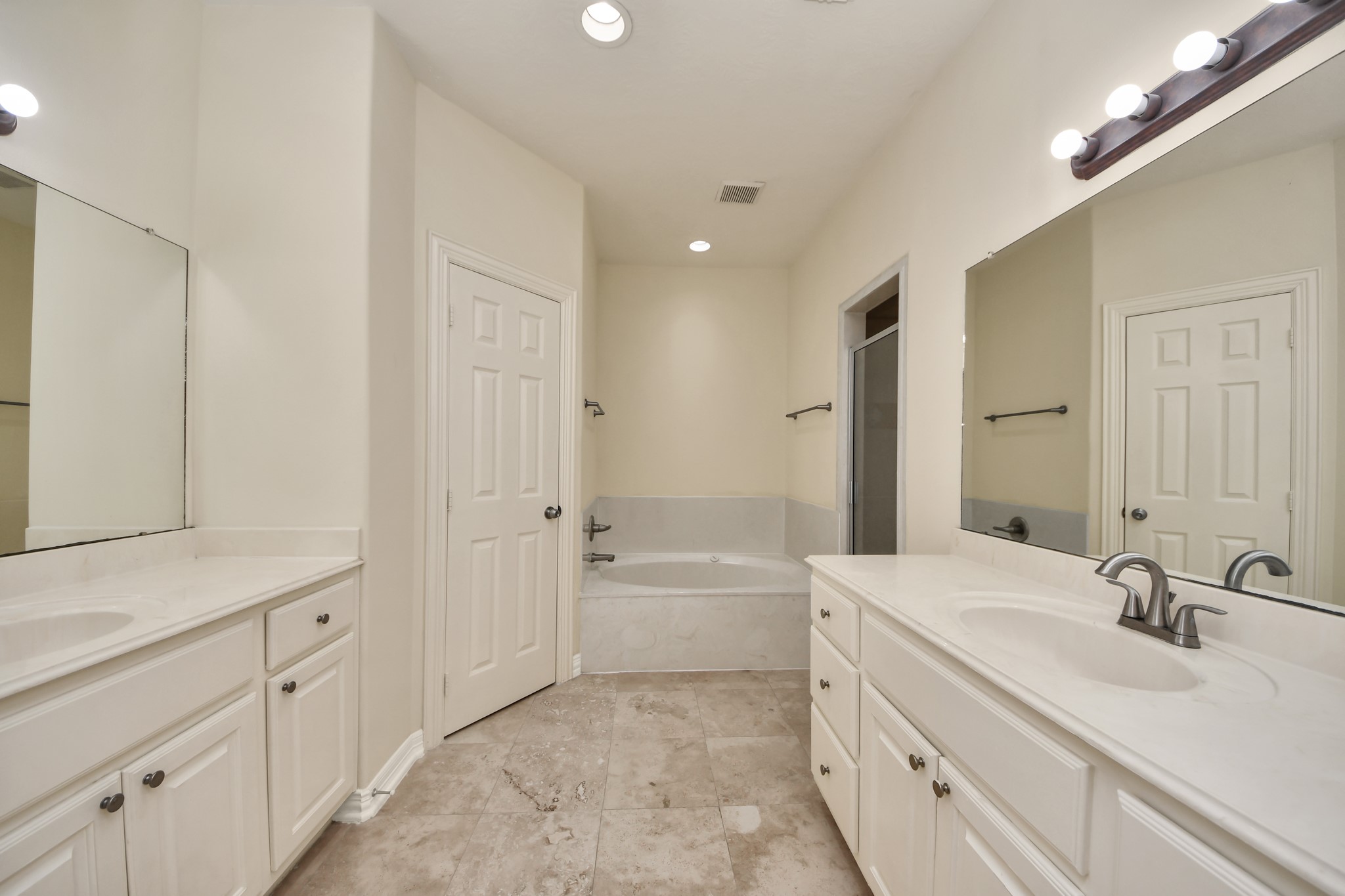 13038 Gentryside Court Houston, TX 77077 - Photo 15 of 20 Spa-like primary en suite with travertine tile, double sinks, relaxing soaking tub, and separate shower