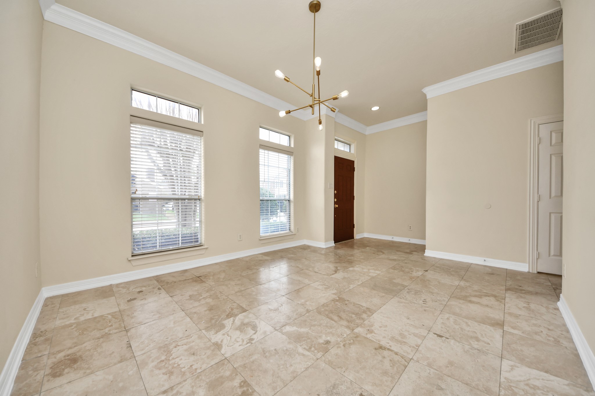 13038 Gentryside Court Houston, TX 77077 - Photo 4 of 20 Another angle of the spacious, partially enclosed dining room showcasing beautiful travertine floors and a stylish modern light fixture—perfect for entertaining.