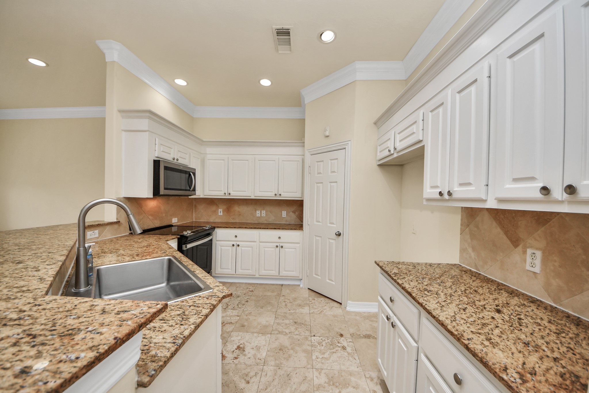 13038 Gentryside Court Houston, TX 77077 - Photo 7 of 20 Well-appointed kitchen with granite countertops, stainless steel appliances, a walk-in pantry, and a deep farmhouse sink.