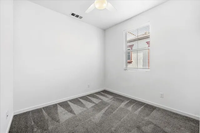 an empty room with a chandeliers fan