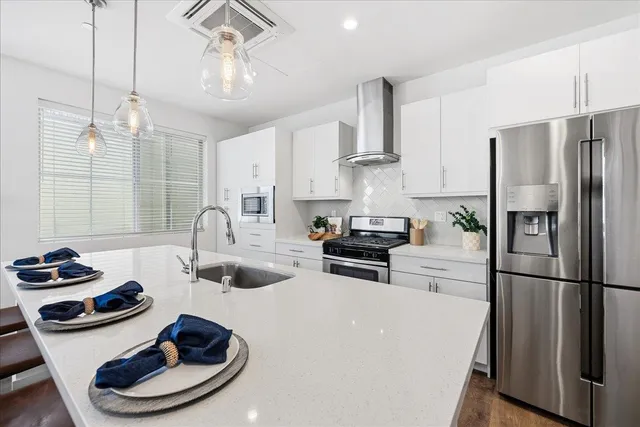 a kitchen with sink a refrigerator and chairs