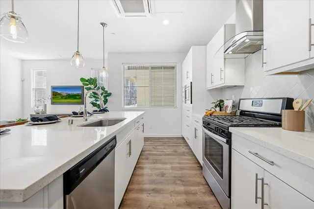 a kitchen with stainless steel appliances a sink stove and cabinets