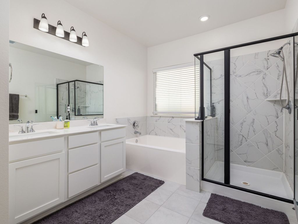 3921 Riardo Drive Round Rock, TX 78665 - Photo 15 of 27 a bathroom with a double vanity sink mirror and shower