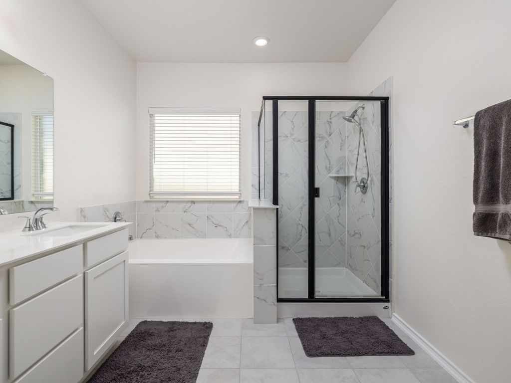 3921 Riardo Drive Round Rock, TX 78665 - Photo 16 of 27 a bathroom with a granite countertop sink a mirror and a bathtub