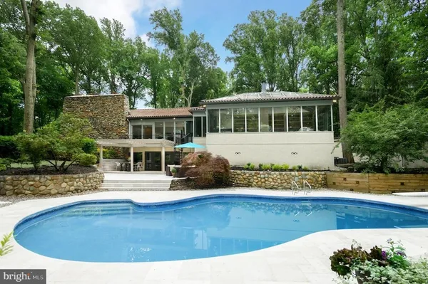 a view of a house with pool and sitting area