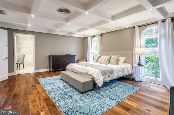 a bedroom with a large bed wooden floor and window