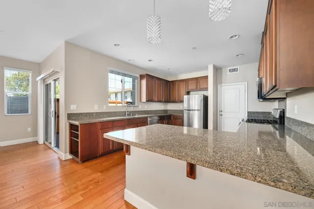 a kitchen with stainless steel appliances granite countertop a sink refrigerator and cabinets