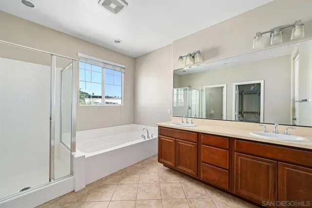 a spacious bathroom with a tub sink shower and mirror