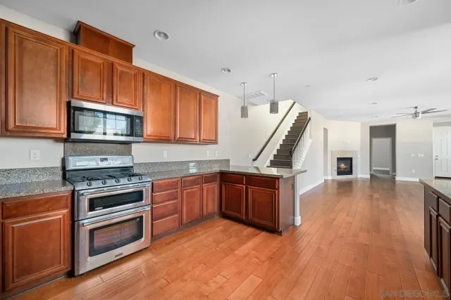 a kitchen with granite countertop a stove top oven and a sink