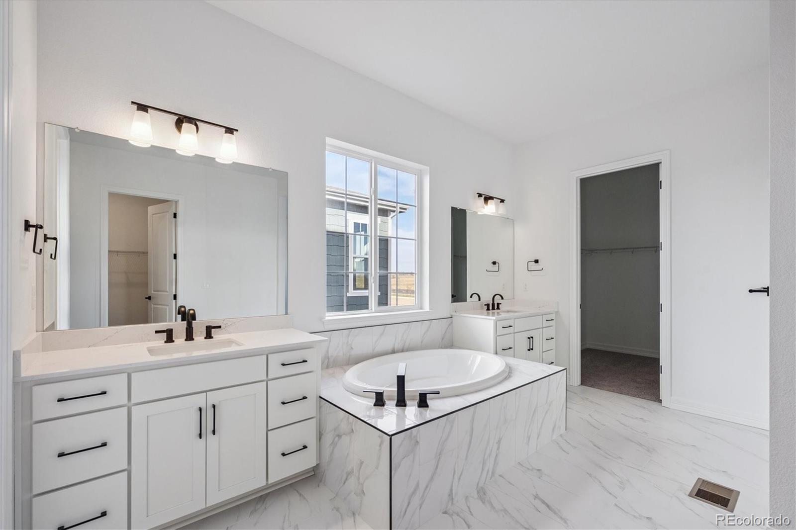 1180 Weller Street Timnath, CO 80547 - Photo 14 of 26 a bathroom with a granite countertop sink mirror bathtub and shower