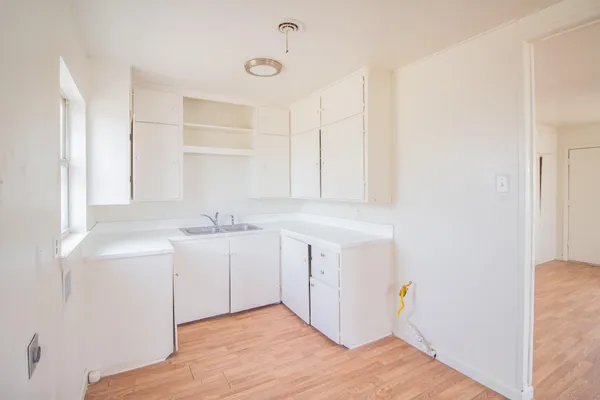 a kitchen with white cabinets and sink