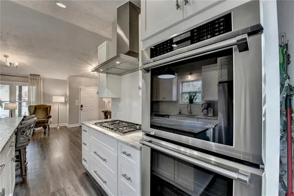 a kitchen with stainless steel appliances granite countertop a stove top oven a sink a counter space and cabinets