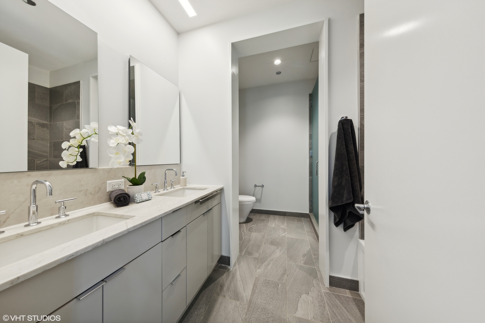 61 East Banks Street, Unit 802 Chicago, IL 60610 - Photo 11 of 23 a bathroom with a double vanity sink a toilet and a mirror