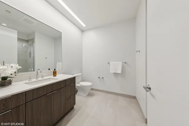 a bathroom with a toilet a sink and mirror