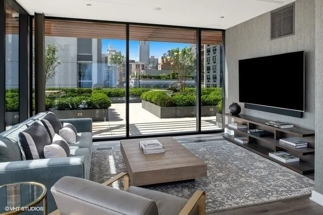 a living room with furniture tv and a floor to ceiling window