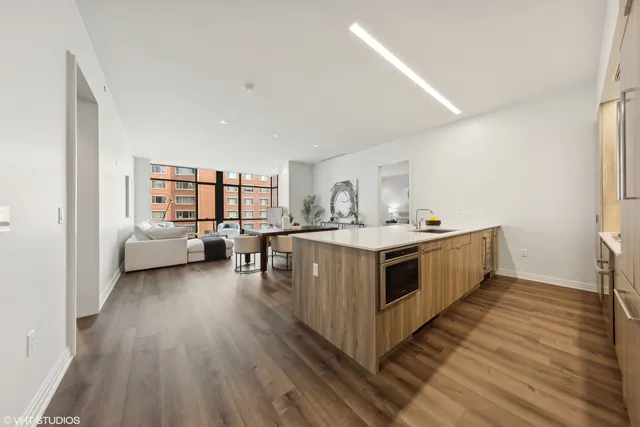 a kitchen with stainless steel appliances a white stove top oven a sink and dishwasher with wooden floor