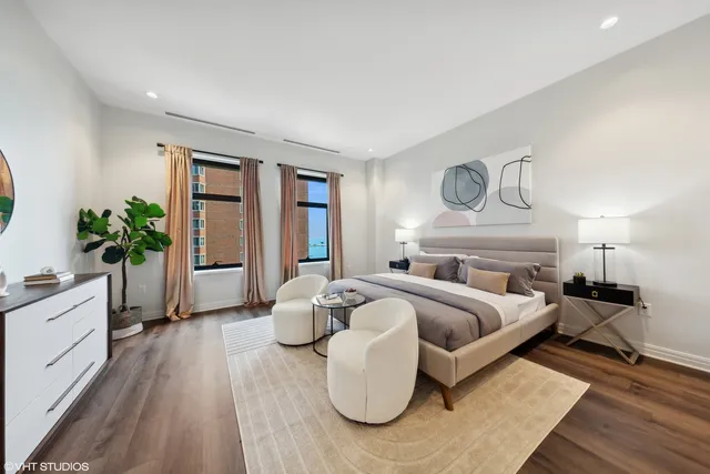 a bedroom with furniture and a large window