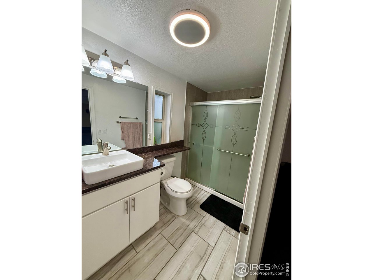 9775 Lark Street Federal Heights, CO 80260 - Photo 10 of 17 a bathroom with a granite countertop toilet sink and mirror