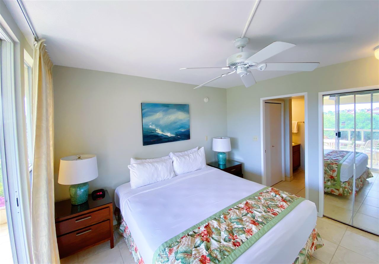 2575 South Kihei Road, Unit Q401/401A Kihei, HI 96753 - Photo 11 of 25 a bedroom with a bed and a chandelier