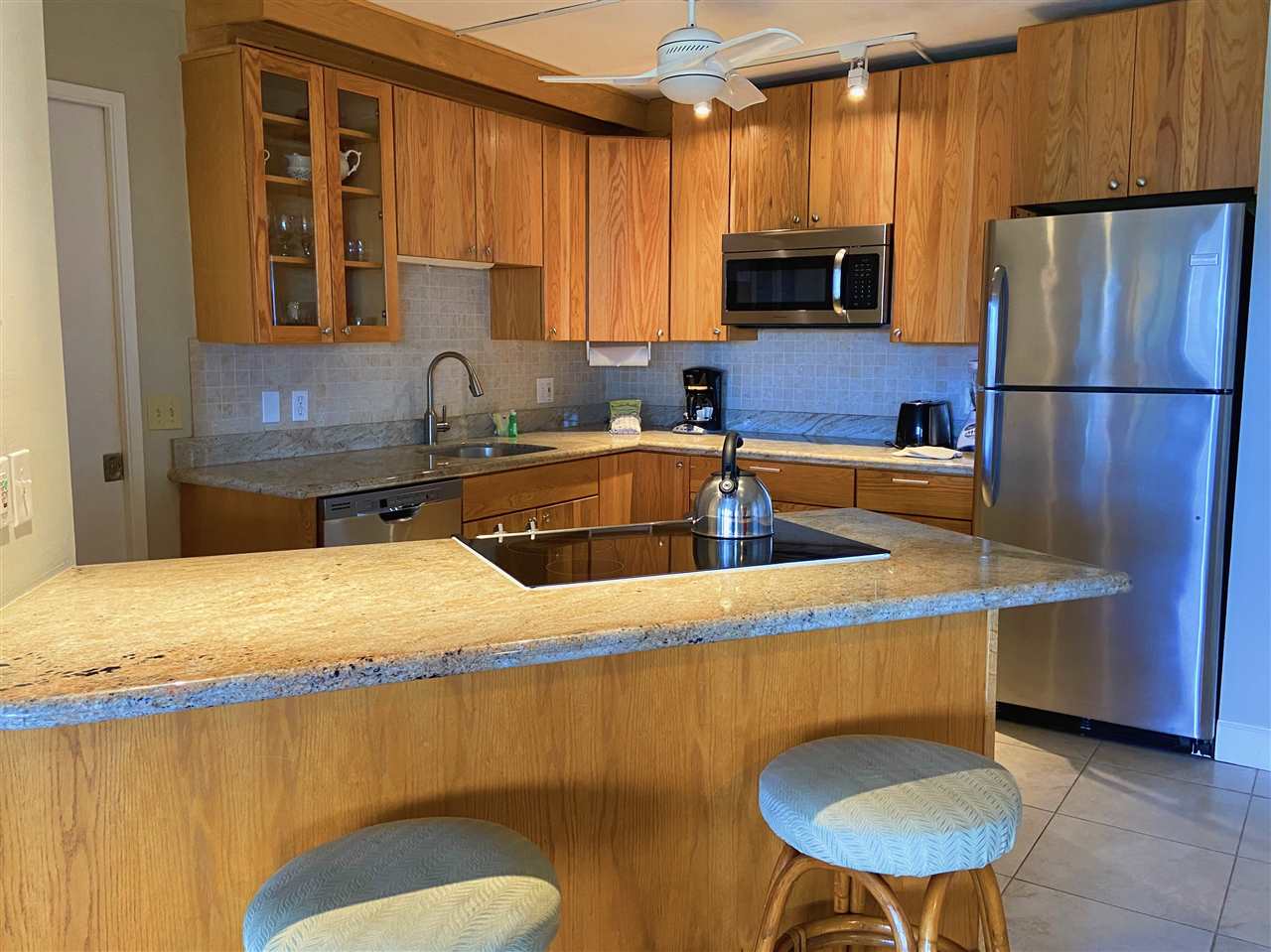 2575 South Kihei Road, Unit Q401/401A Kihei, HI 96753 - Photo 4 of 25 a kitchen with stainless steel appliances granite countertop a sink refrigerator and microwave