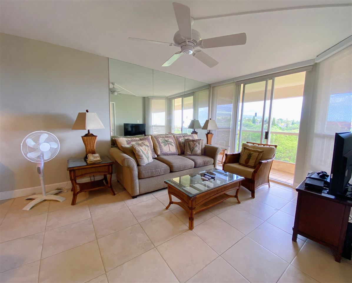 2575 South Kihei Road, Unit Q401/401A Kihei, HI 96753 - Photo 9 of 25 a living room with furniture a flat screen tv and a large window