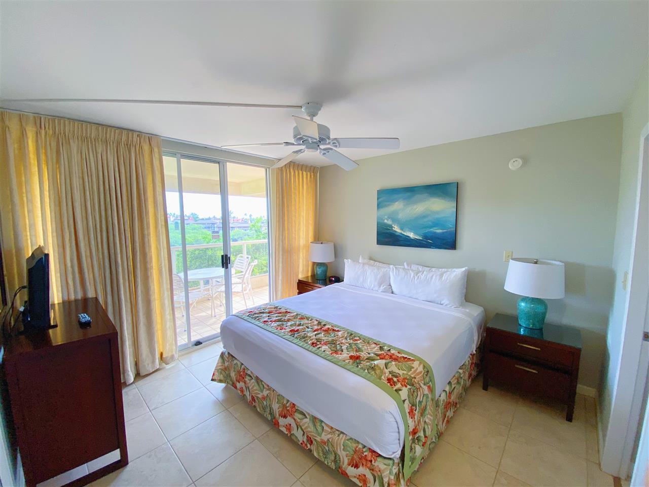 2575 South Kihei Road, Unit Q401/401A Kihei, HI 96753 - Photo 10 of 25 a bedroom with a bed and a chandelier