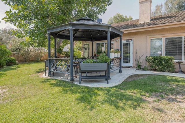 a view of a chair and table in backyard of the house