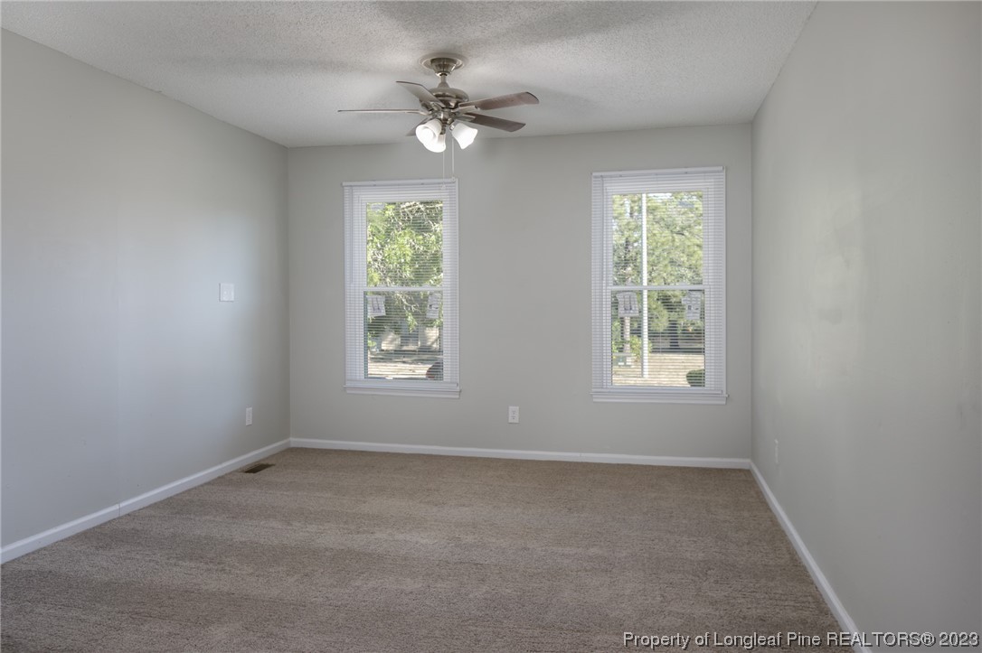 4514 Ruby Road Fayetteville, NC 28311 - Photo 10 of 21 an empty room with windows and fan