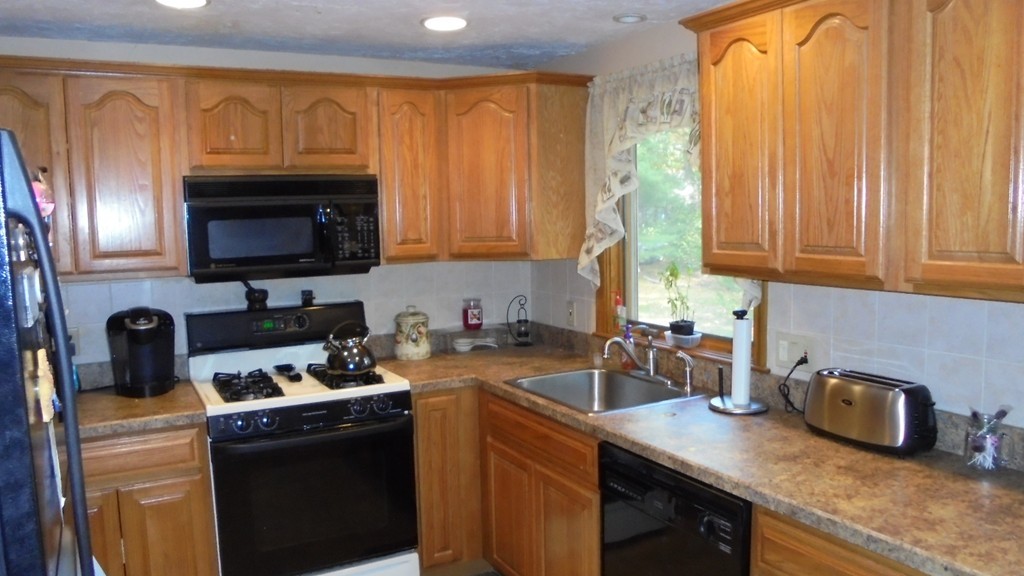 108 Wyman Road Billerica, MA 01821 - Photo 4 of 21 a kitchen with granite countertop a sink a stove a microwave and refrigerator