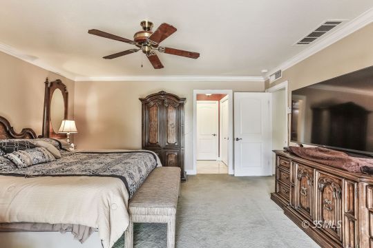 1509 Welcome Way Ridgecrest, CA 93555 - Photo 39 of 50 a bedroom with a bed a mirror and a ceiling fan