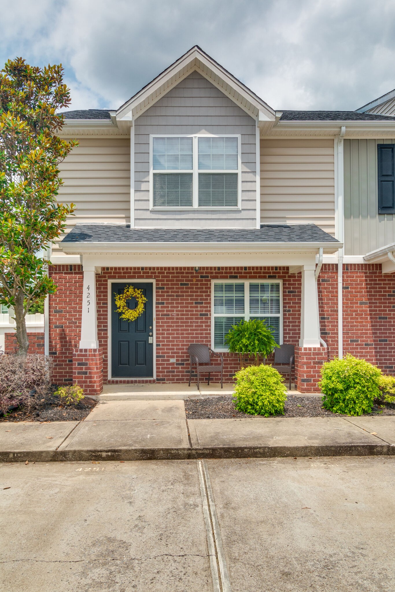 a front view of a house with garden and parking space