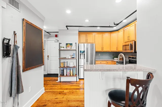 a kitchen with stainless steel appliances granite countertop a stove a sink and a refrigerator