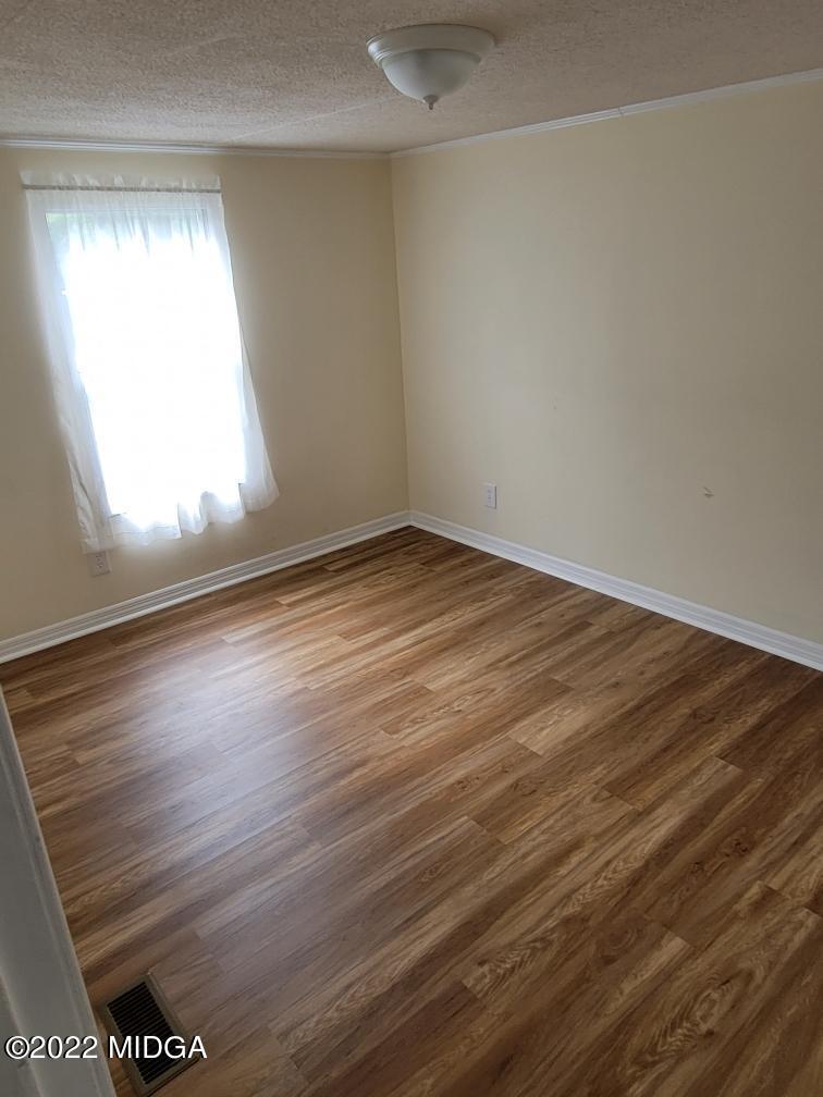 4460 Fulton Mill Road Macon, GA 31216 - Photo 20 of 23 an empty room with wooden floor and windows