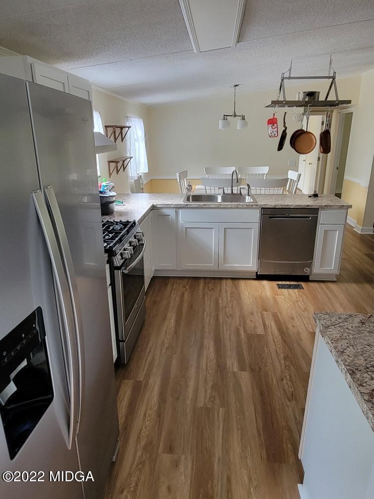 4460 Fulton Mill Road Macon, GA 31216 - Photo 6 of 23 a kitchen with stainless steel appliances granite countertop a sink a stove a refrigerator and wooden floor