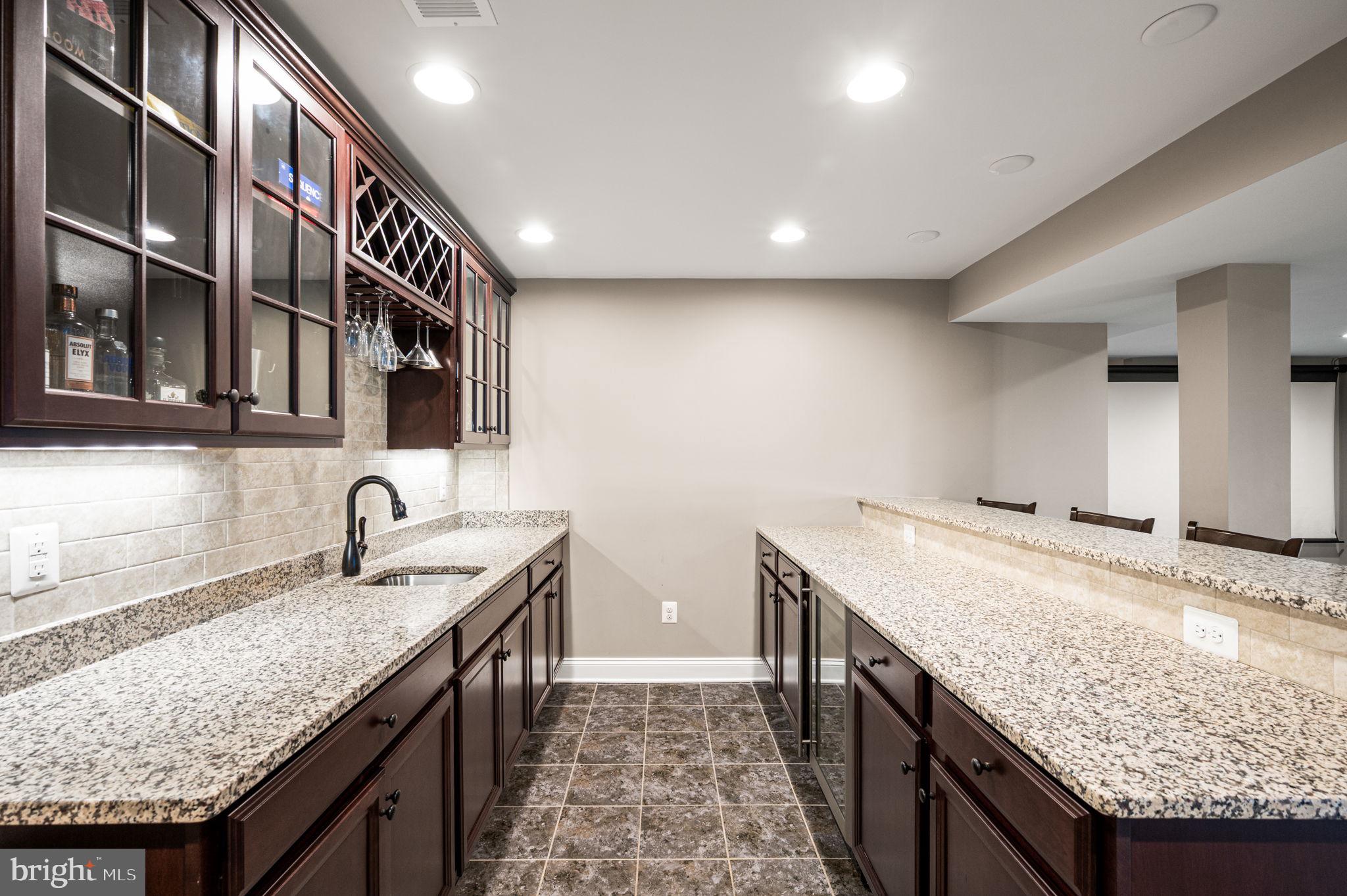 612 Quarry Point Road Malvern, PA 19355 - Photo 38 of 44 a kitchen with granite countertop kitchen island a sink wooden cabinets and entryway