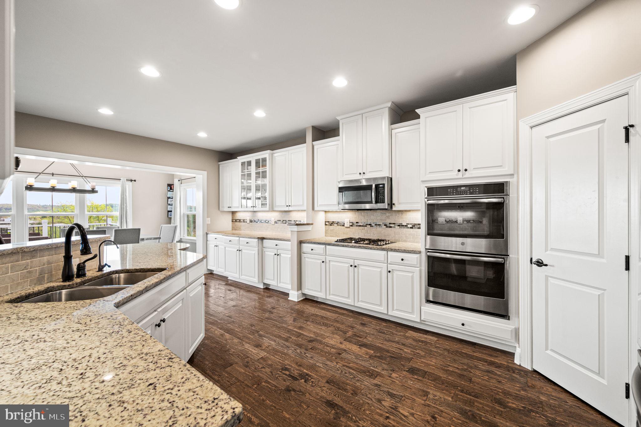 612 Quarry Point Road Malvern, PA 19355 - Photo 10 of 44 a large white kitchen with stainless steel appliances granite countertop a stove a sink a refrigerator and white cabinets with wooden floor