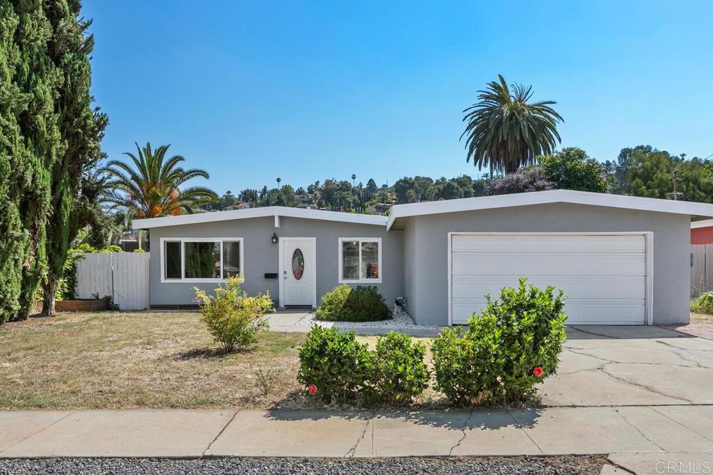 a front view of house with yard and trees around