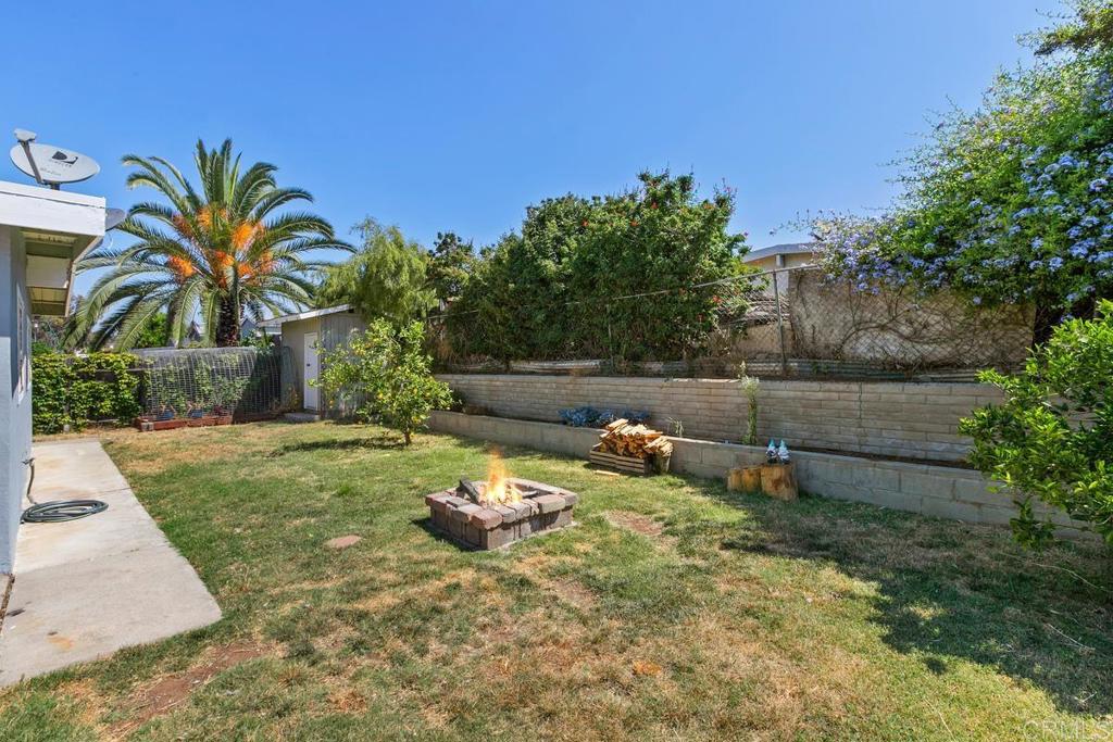 1451 Gowin Street Spring Valley, CA 91977 - Photo 20 of 24 a view of a backyard with lawn chairs plants and palm tree